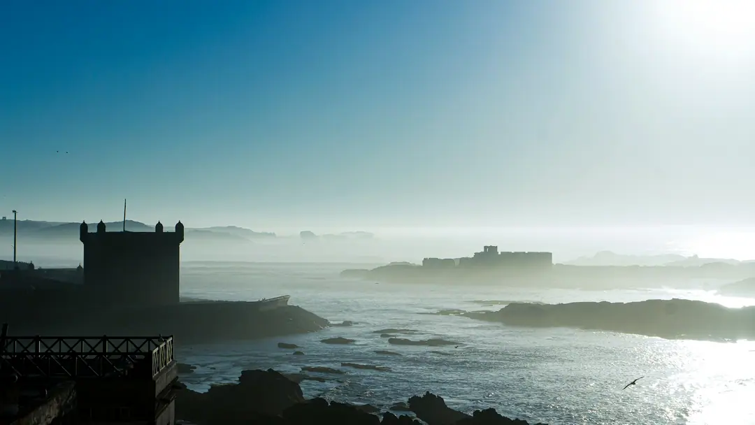 The silhouette of an Essaouira bastion above the sea in the haze