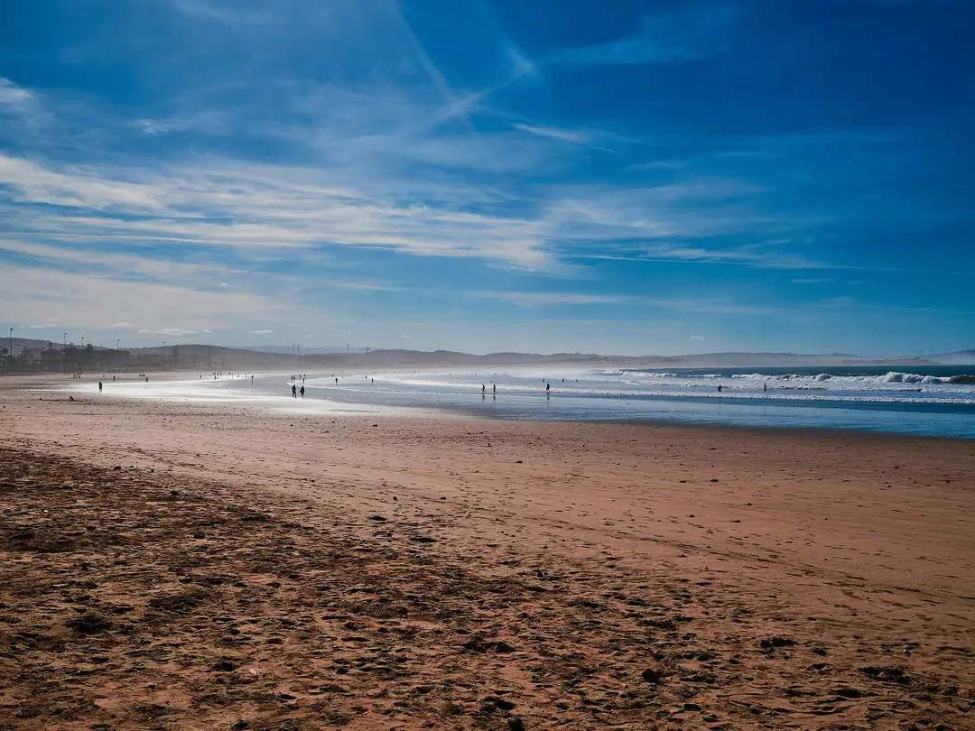 Essaouira's wide sandy beach under a big blue sky