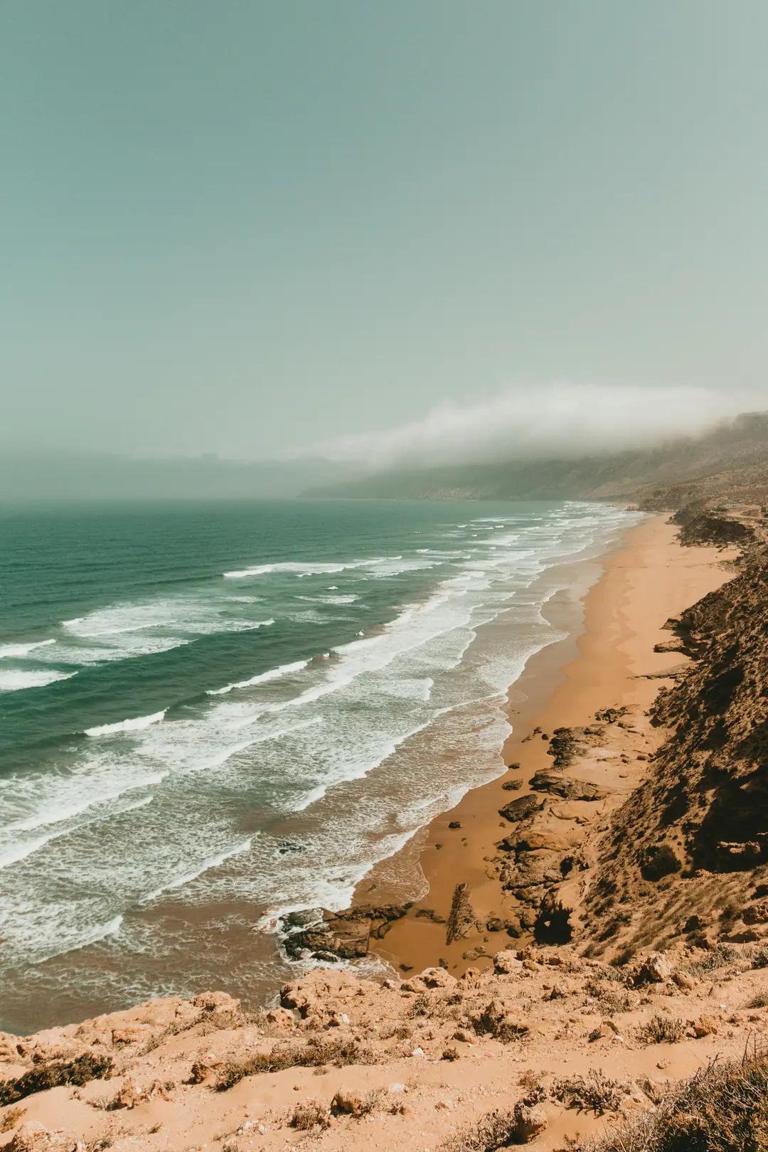 Atlantic waves rolling onto a long sandy beach on the Essaouira coast