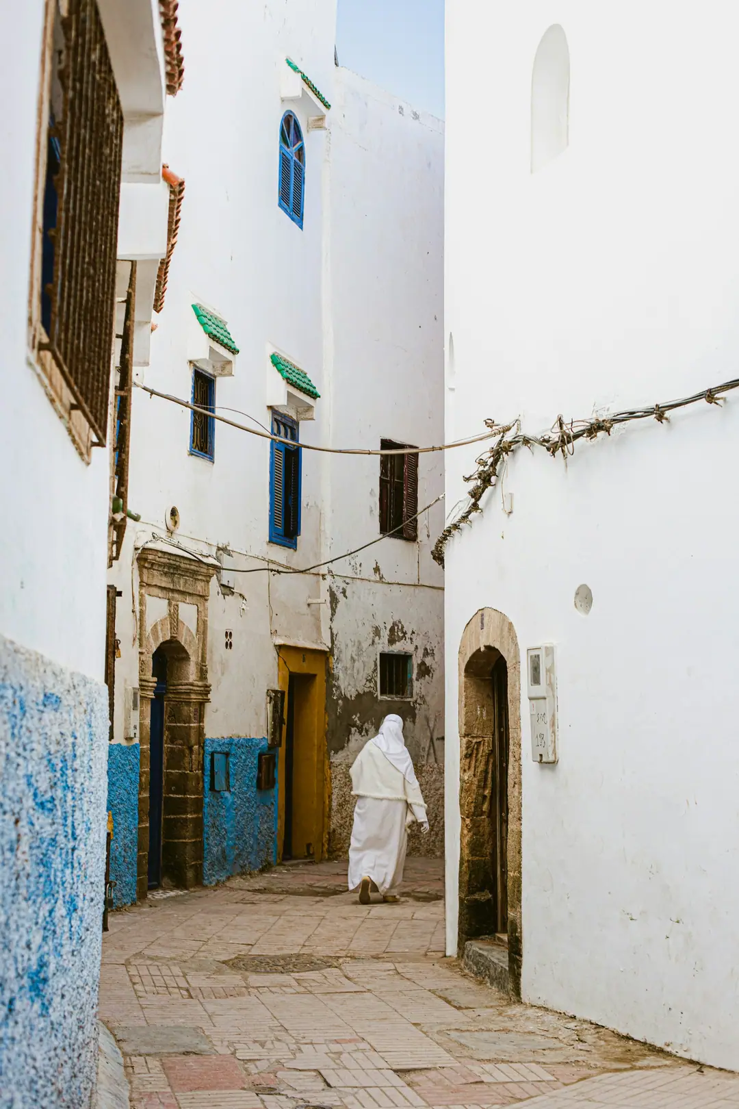 A whitewashed lane in Essaouira medina with blue walls and shutters