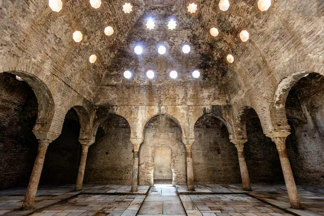 A vaulted hammam hall with horseshoe arches and star-shaped skylights