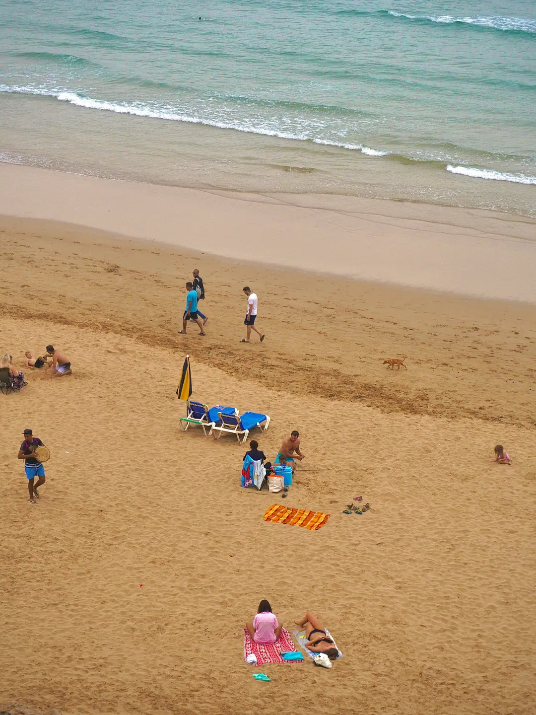 Summer beach-goers and parasols on a Moroccan Atlantic beach