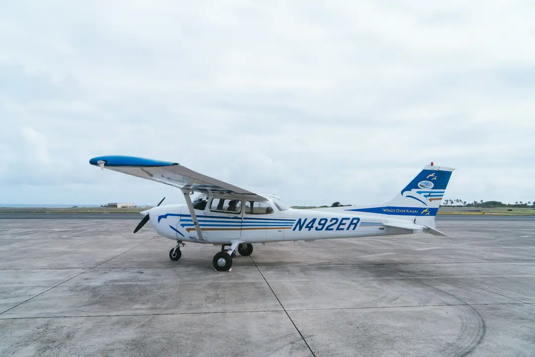 A small single-engine plane parked on an airport apron